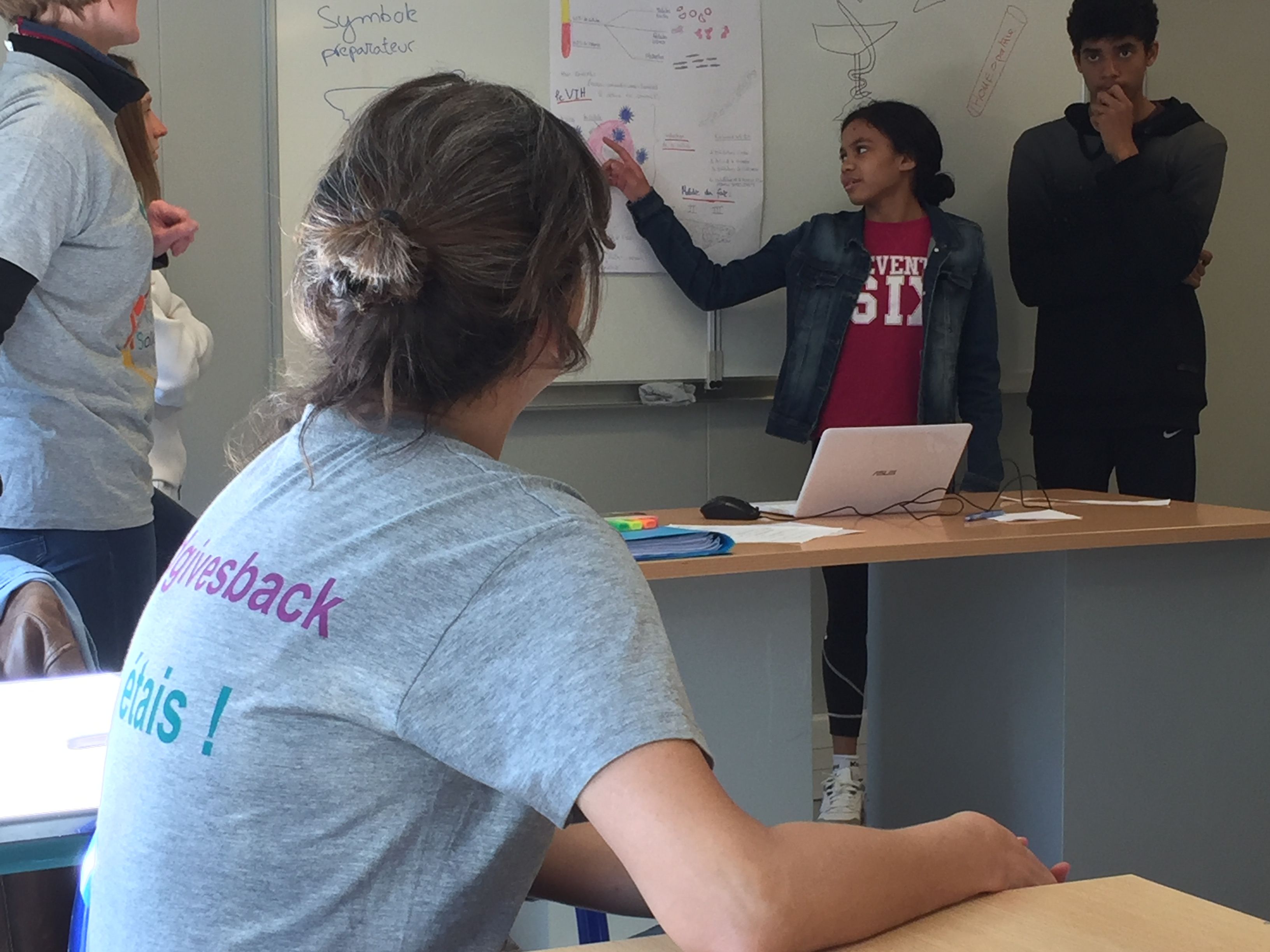 Personnes discutant devant un tableau