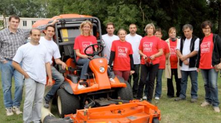 Photo d'un groupe de personne en extérieur avec une tondeuse